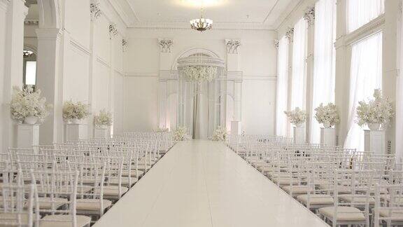 室内婚礼仪式拱门和白色椅子