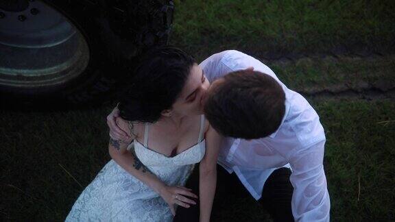 相爱的情侣坐在草地上拥抱亲吻