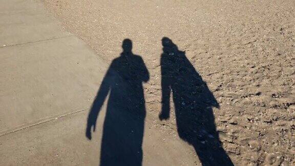 沙滩上一对情侣的影子