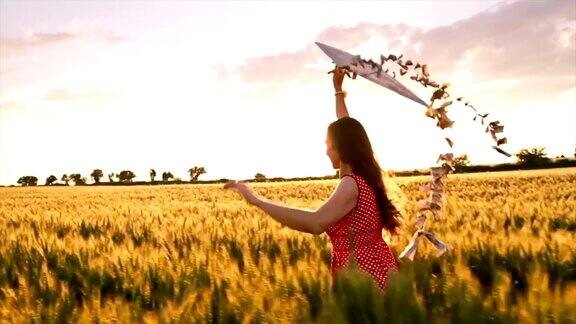 女人跑与风筝日落夏季自由慢动作