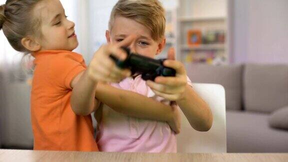 小女孩打扰弟弟玩掌机游戏孩子们打操纵杆