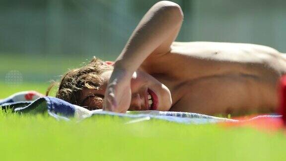 孩子躺在草地上晒太阳小男孩在户外做白日梦