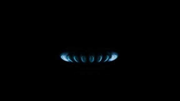 燃烧煤气炉炉台蓝色火焰微距在黑暗中的黑色背景煤气开关打开出现蓝色火焰煤气炉上孤立在黑色背景上