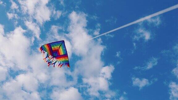 一只风筝在蓝天白云的映衬下飞翔