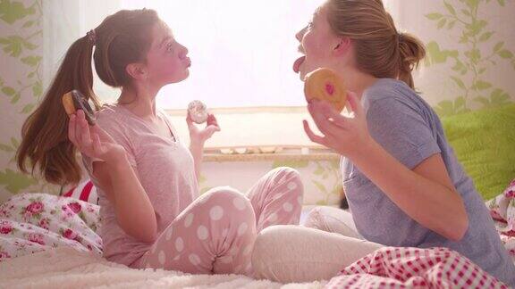 女孩们在睡衣派对上傻乎乎地吃着甜甜圈