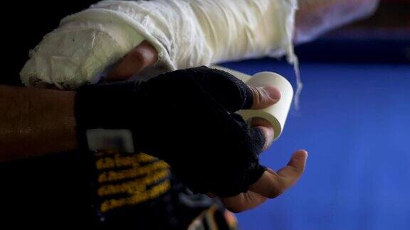 摔跤手在训练前小心地用弹性绷带缠绕受伤的手臂