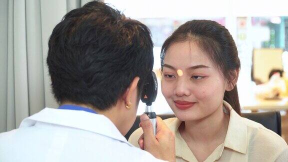 验光师调整视网膜镜和主观屈光的距离测试亚洲年轻女性的视力准备配眼镜