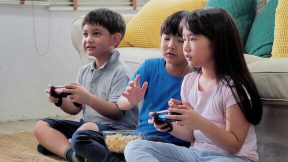 一群孩子在家里玩电子游戏开心又好玩早期教育和学习教育、儿童、技术、科学和人的观念