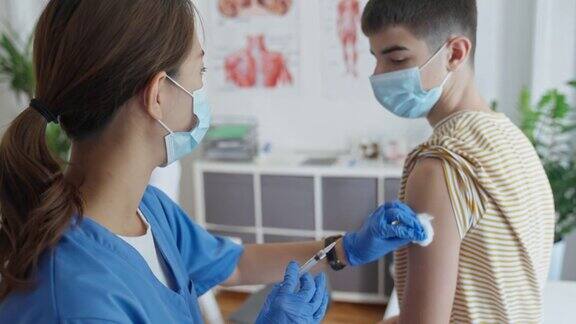 在疫苗接种中心女护士正在给青少年接种新冠疫苗