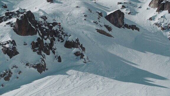 一名专业滑雪者从岩石山坡上滑下来的视频