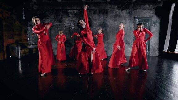 7名迷人的女舞者在排练厅跳舞穿着红色的裙子躺在地板上