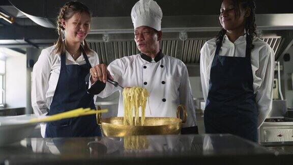 亚洲资深厨师在厨房教不同的学生烹饪