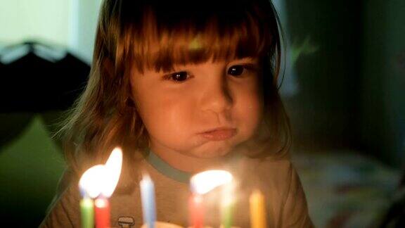 小男孩吹灭生日蛋糕上的蜡烛特写镜头缓慢的运动