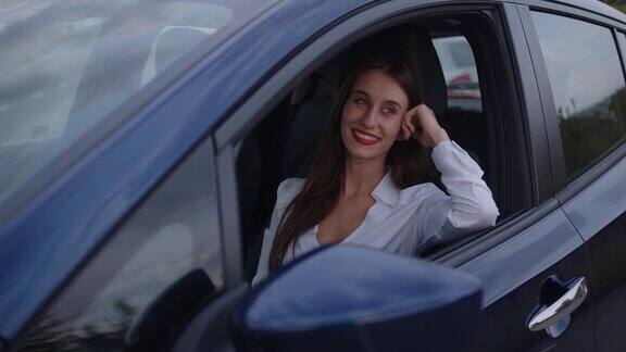 一个年轻的女人坐在驾驶座上微笑着