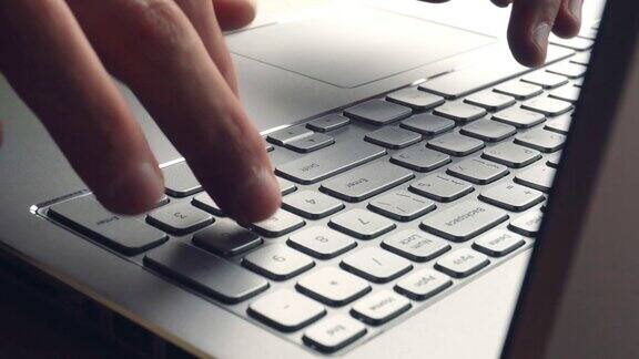 笔记本电脑键盘打字手在笔记本电脑键盘上打字的特写