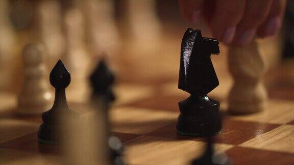 在一盘国际象棋中一个涂着粉色指甲油的白人妇女将对手的骑士从棋盘上移除