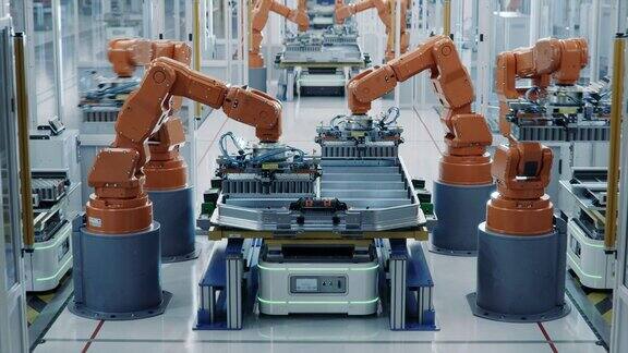 光明工厂内的一排机械臂为汽车工业组装电池配备橙色先进机械臂的电动汽车电池组自动化生产线现代电动汽车智能工厂