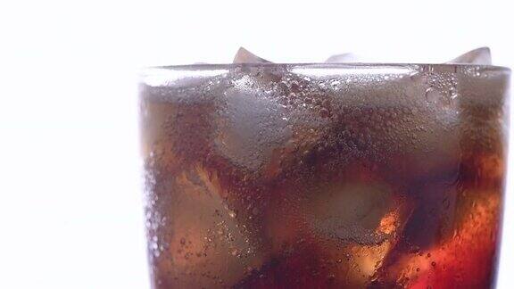 将可乐倒在白色背景的冰块上饮料和饮料的特写镜头