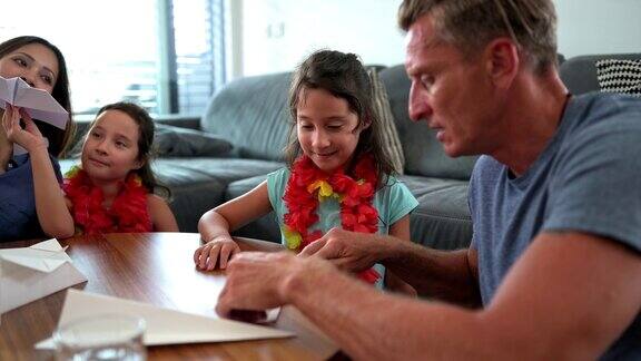 多民族家庭在室内玩纸飞机