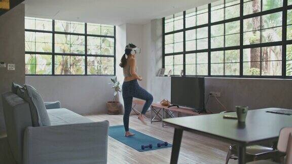 年轻女子在家中客厅佩戴VR头戴式跑步模拟器运动手机app
