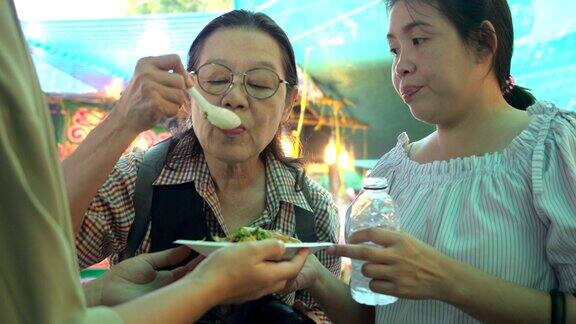 泰国街头小吃她们来市场观光那里是夜生活的场所是吃饭的好地方