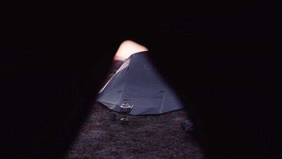 在大自然中独自在山上露营的游客拍摄日落