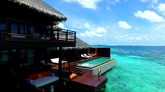 马尔代夫蓝天蓝绿色的海白色的沙子和绿色的棕榈树