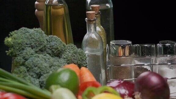 新鲜蔬菜装着油和醋的瓶子厨房桌子上的香料罐