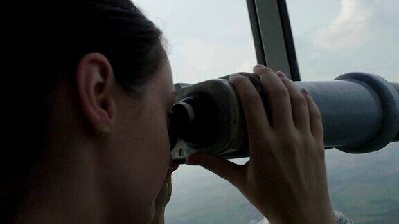 小女孩用公共望远镜看东西
