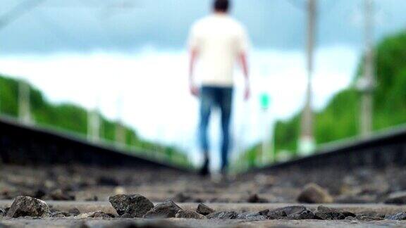 一个孤独的男人沿着铁轨走到模糊的地方