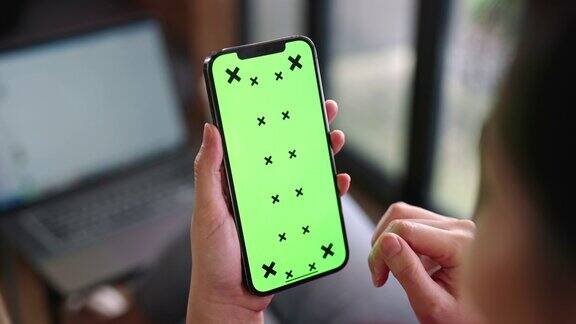 女人用绿色屏幕的智能手机
