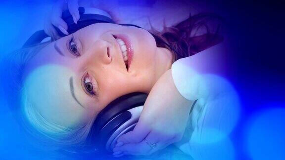蓝色的灯光和迷人的年轻女子在听音乐