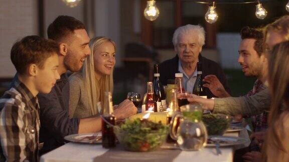 一群人围坐在一张桌子上在家庭晚餐期间吃交流和玩