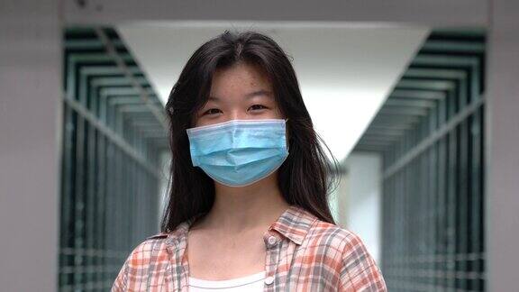 一个亚洲女人的肖像戴着面具看着镜头预防Covid-19或冠状病毒概念