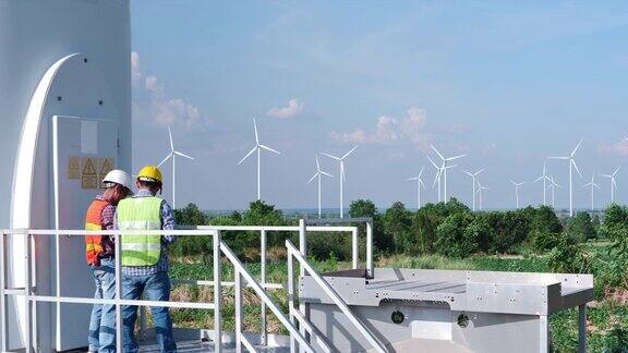 两名亚洲工程师正在检查风电场中风力发电机的运行以生产电力