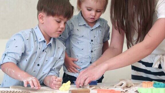 可爱的小男孩和妈妈一起擀面团做饼干