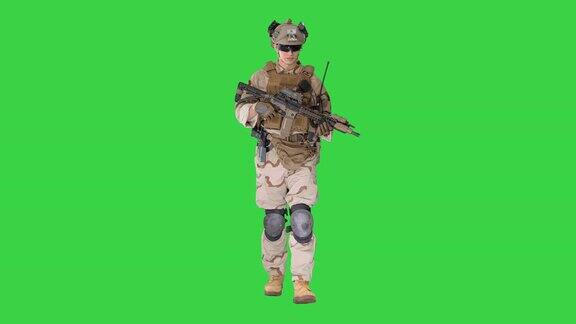 一名身穿战斗制服的美国陆军士兵在绿屏上行走
