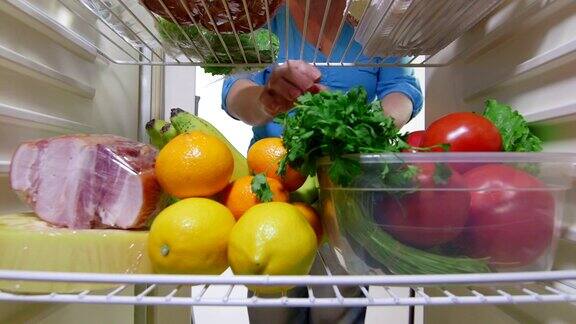 家庭主妇从冰箱里拿出蔬菜
