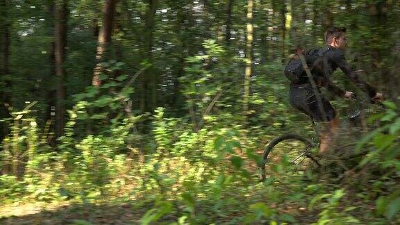 一个骑自行车的人沿着一条穿过森林边景色的小路骑车