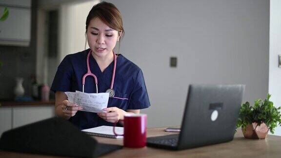 亚裔华人女医生使用笔记本电脑虚拟连接与病人交流