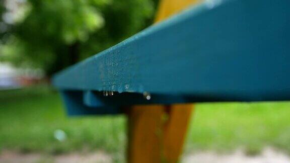 雨水从公园的长凳上流下来春天的雨天