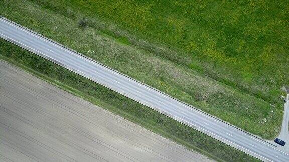 无人机鸟瞰图从道路上移动的汽车运行在田野