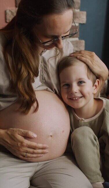 小男孩和他怀孕的妈妈在一起