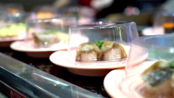 在日本餐厅吃寿司不同配料的传送带寿司有两个寿司的轨迹