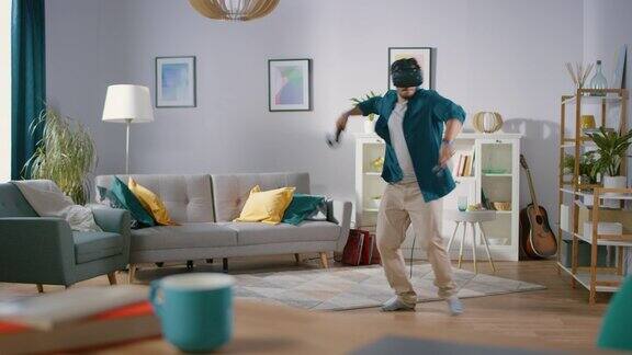 精力充沛的年轻人戴着虚拟现实耳机手持控制器在家玩视频游戏在客厅中玩VR网球的男人