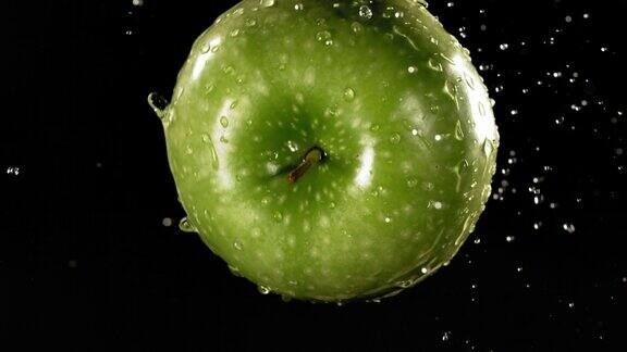 绿苹果在黑色背景下飞行的慢动作