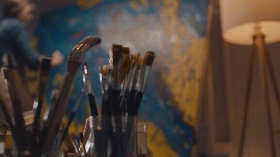 不可辨认的女艺术家用画笔在画布上作画