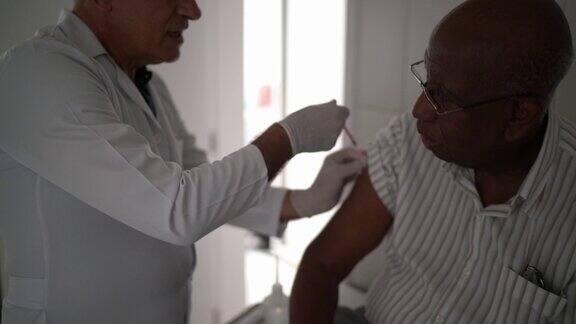 女医生给一个年长的病人注射疫苗