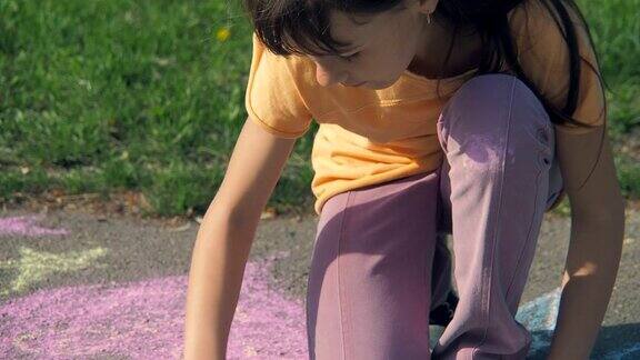 一个女孩用粉笔在沥青上画了一颗心