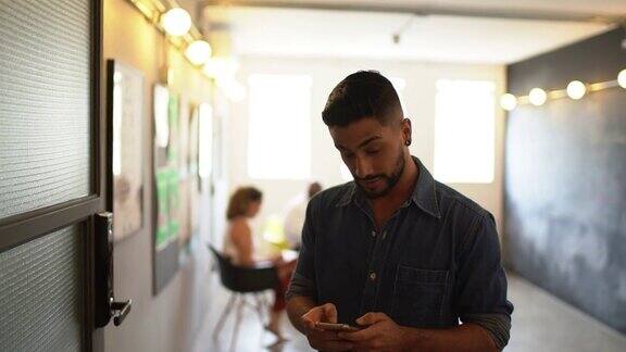 拉丁男性在工作室使用手机拍照